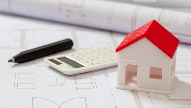 calculator-and-house-model-on-blueprint-background-construction-cost-concept-1024x579