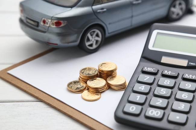 car-model-calculator-and-coins-on-white-table-scaled