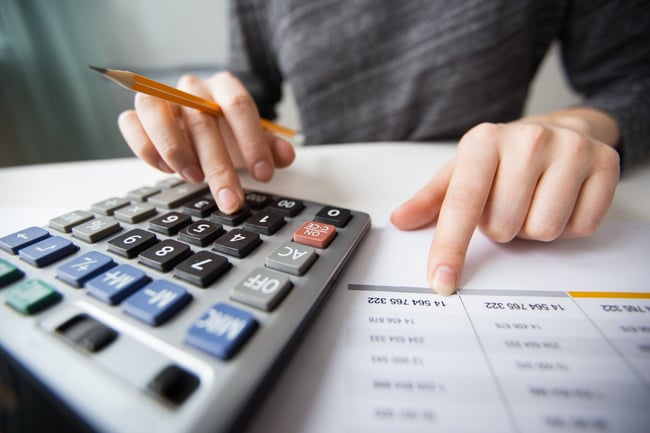 closeup-of-accountant-hands-counting-on-calculator-scaled