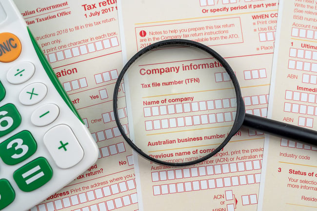 magnifying-glass-pen-and-calculator-on-australian-tax-form-scaled