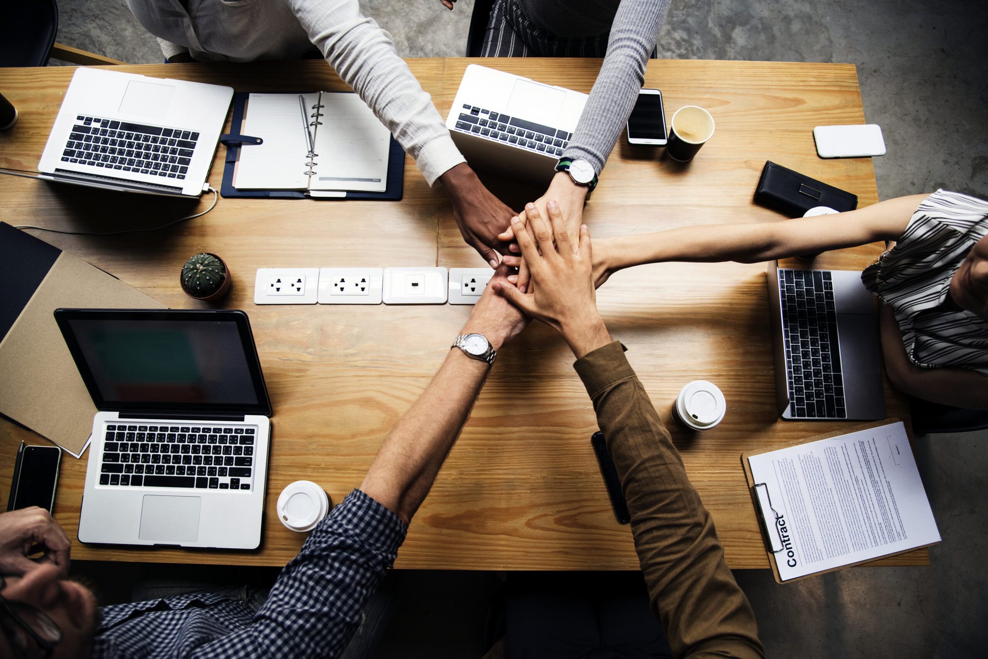 team-of-business-people-stacking-hands-scaled
