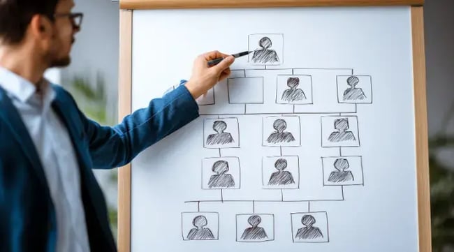 Mężczyzna wskazuje na tablice z drzewem genealogicznym