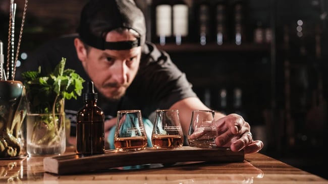 mężczyzna w czapce przygotowuje drinki