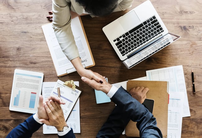business-people-shaking-hands-together-scaled
