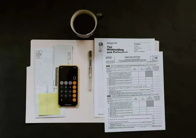 telefon leży na dokumentach obok stoi kubek