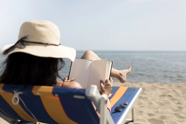 kobieta na plaży czyta na leżaku