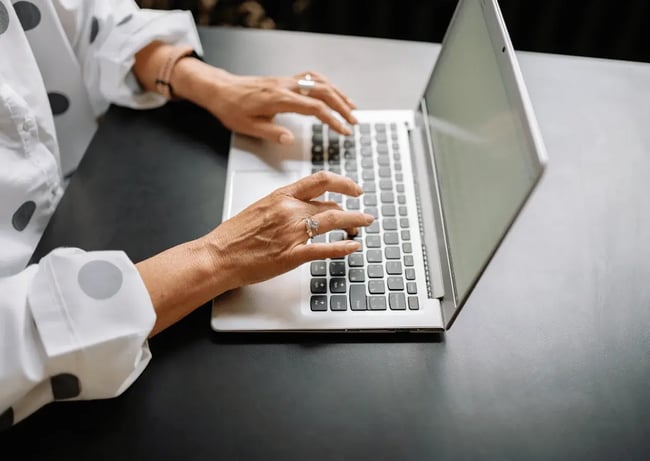 pani pisze na klawiaturze laptopa