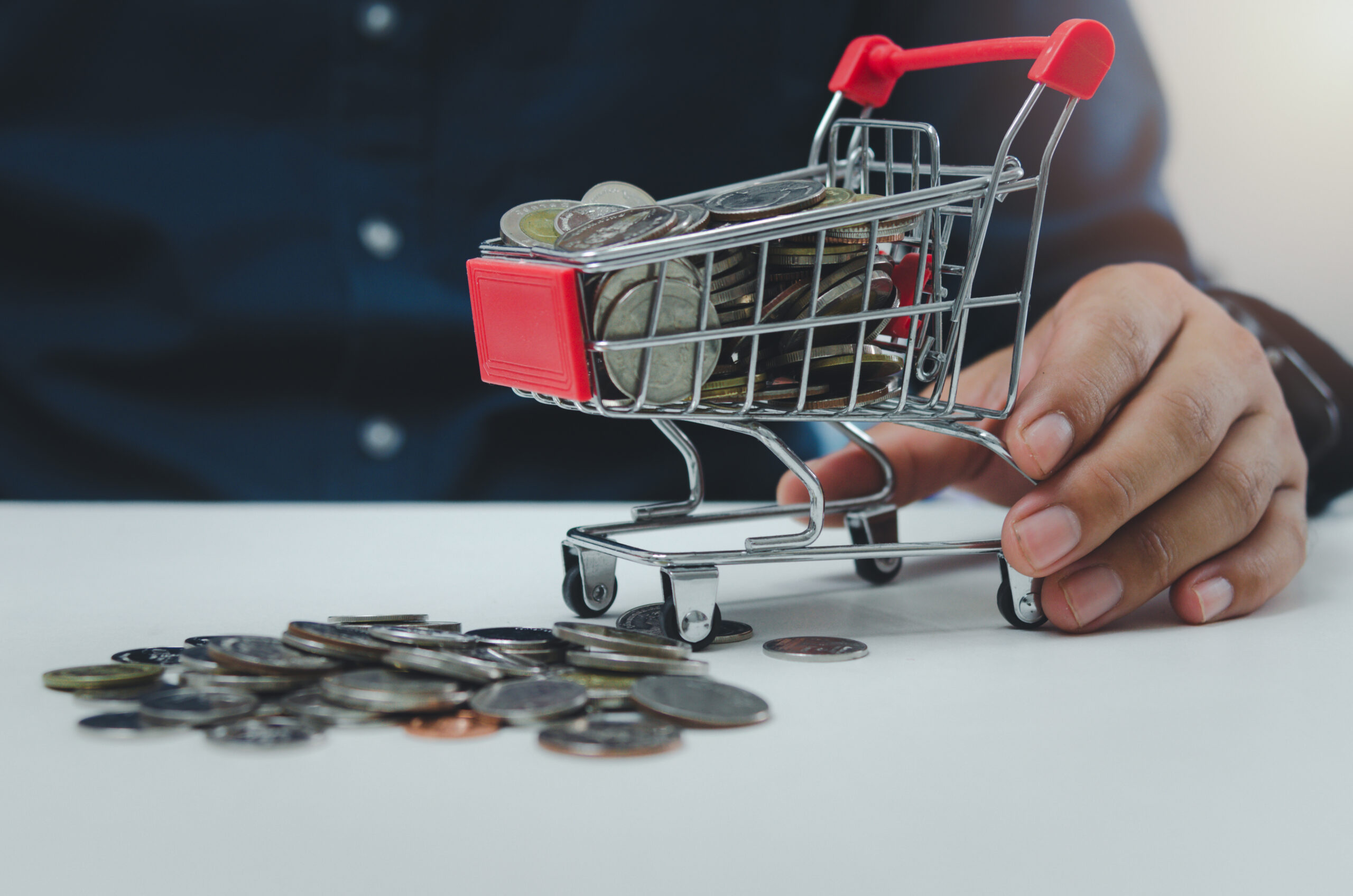 business-finance-investment-economy-or-shopping-online-marketing-and-saving-tax-conceptbusinessman-holding-cart-at-coin-scaled