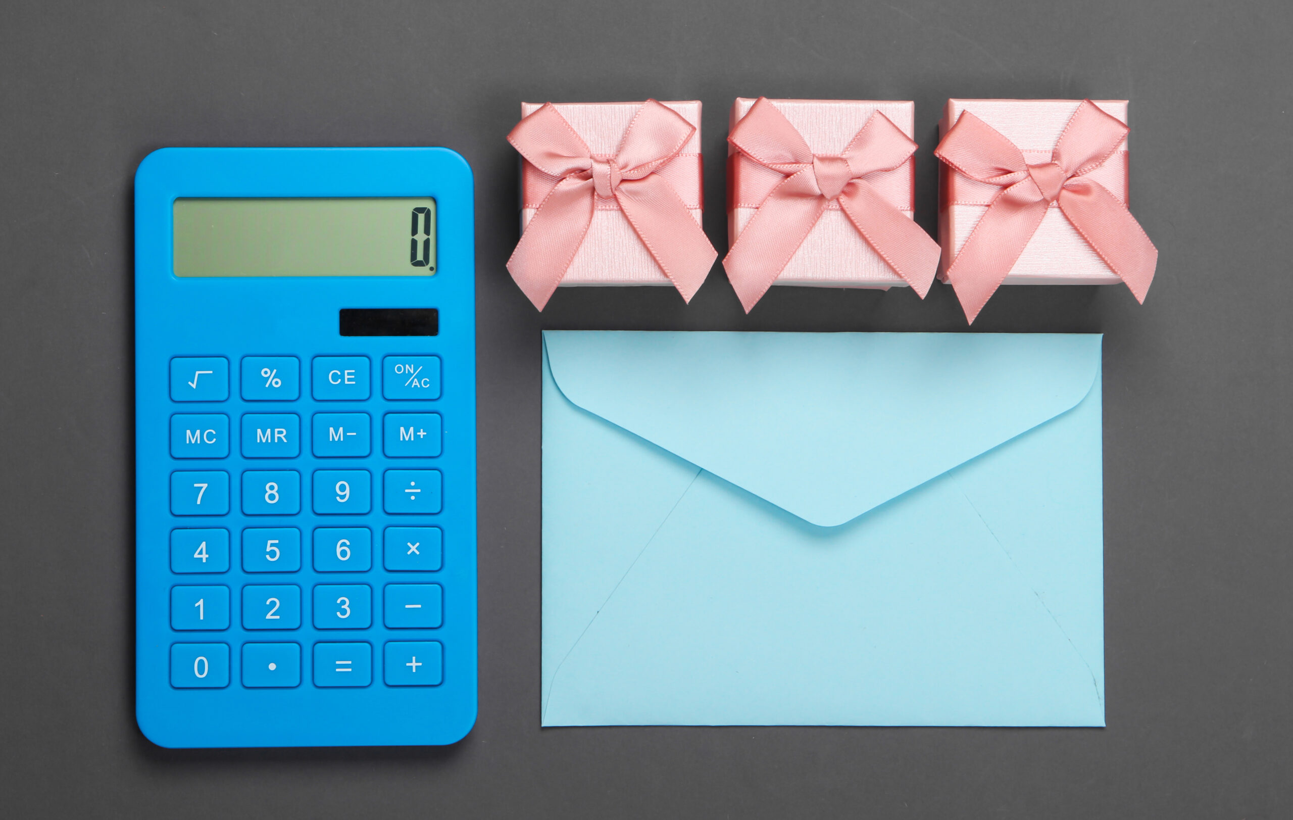 calculator-with-envelope-and-gift-box-on-gray-scaled