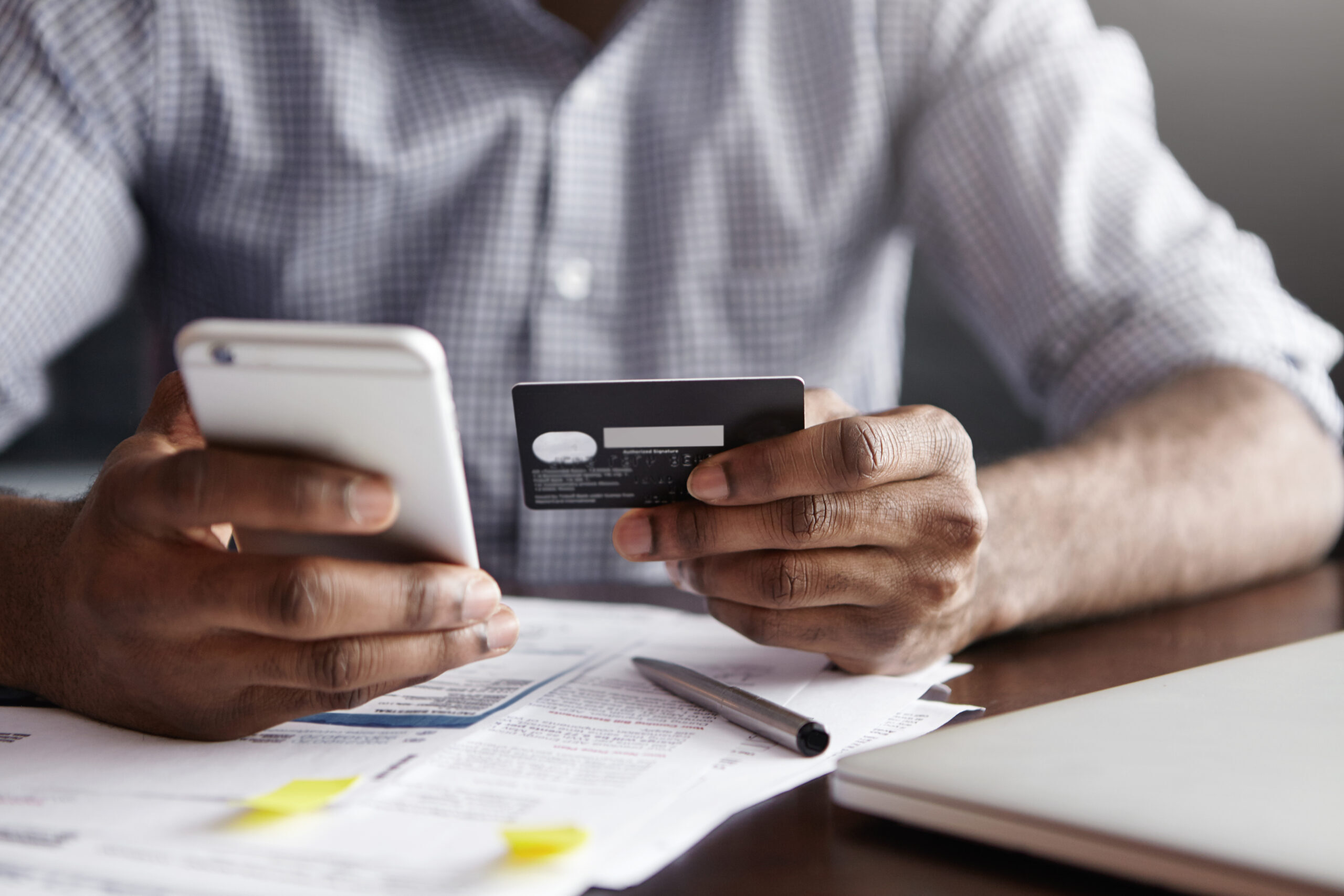 cropped-shot-of-african-american-male-paying-bill-at-restaurant-with-online-payment-technology-scaled