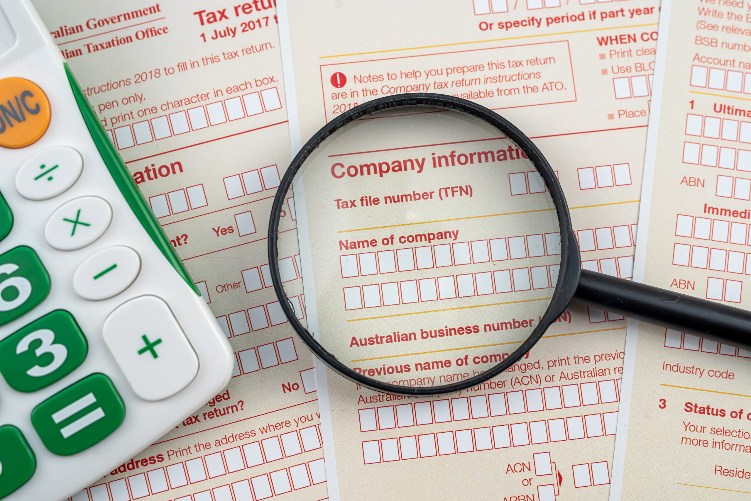 magnifying-glass-pen-and-calculator-on-australian-tax-form-scaled-1