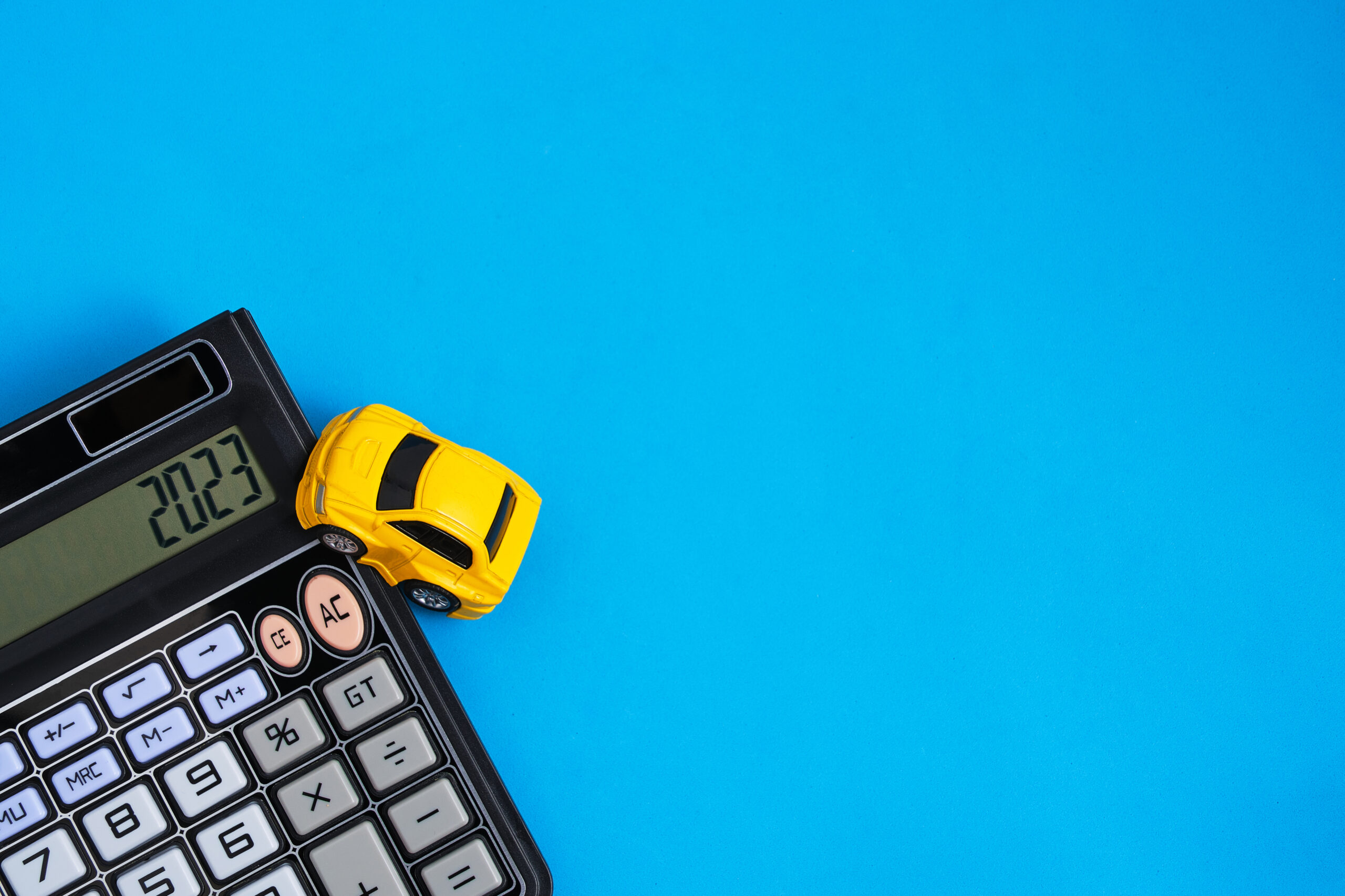 toy-car-and-calculator-blue-backgroundconcept-buying-car-scaled