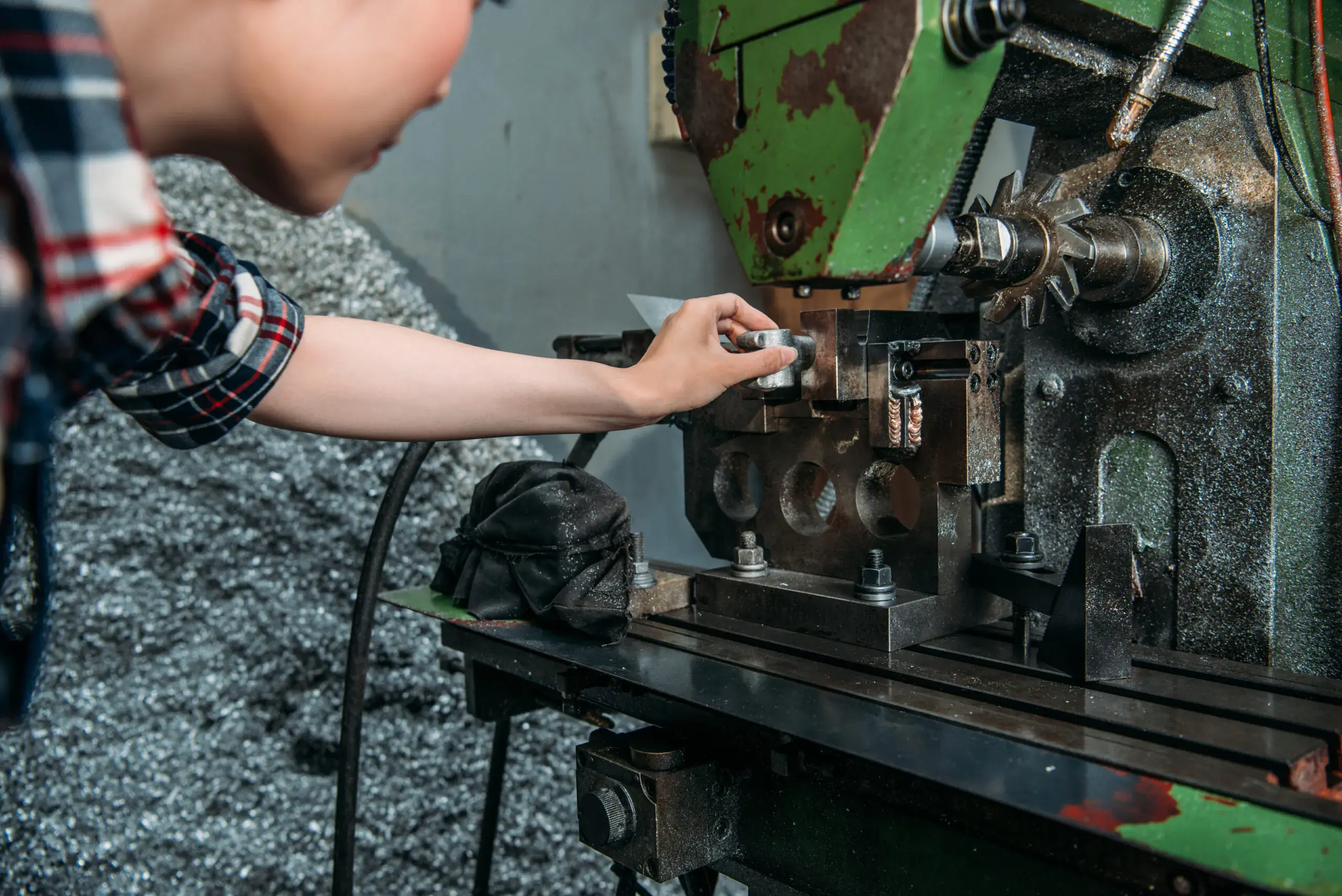 beautiful-industrial-factory-woman-insert-silver-component-into-machine-and-looking-at-exactly-right-place-get-on-drilling-work-scaled
