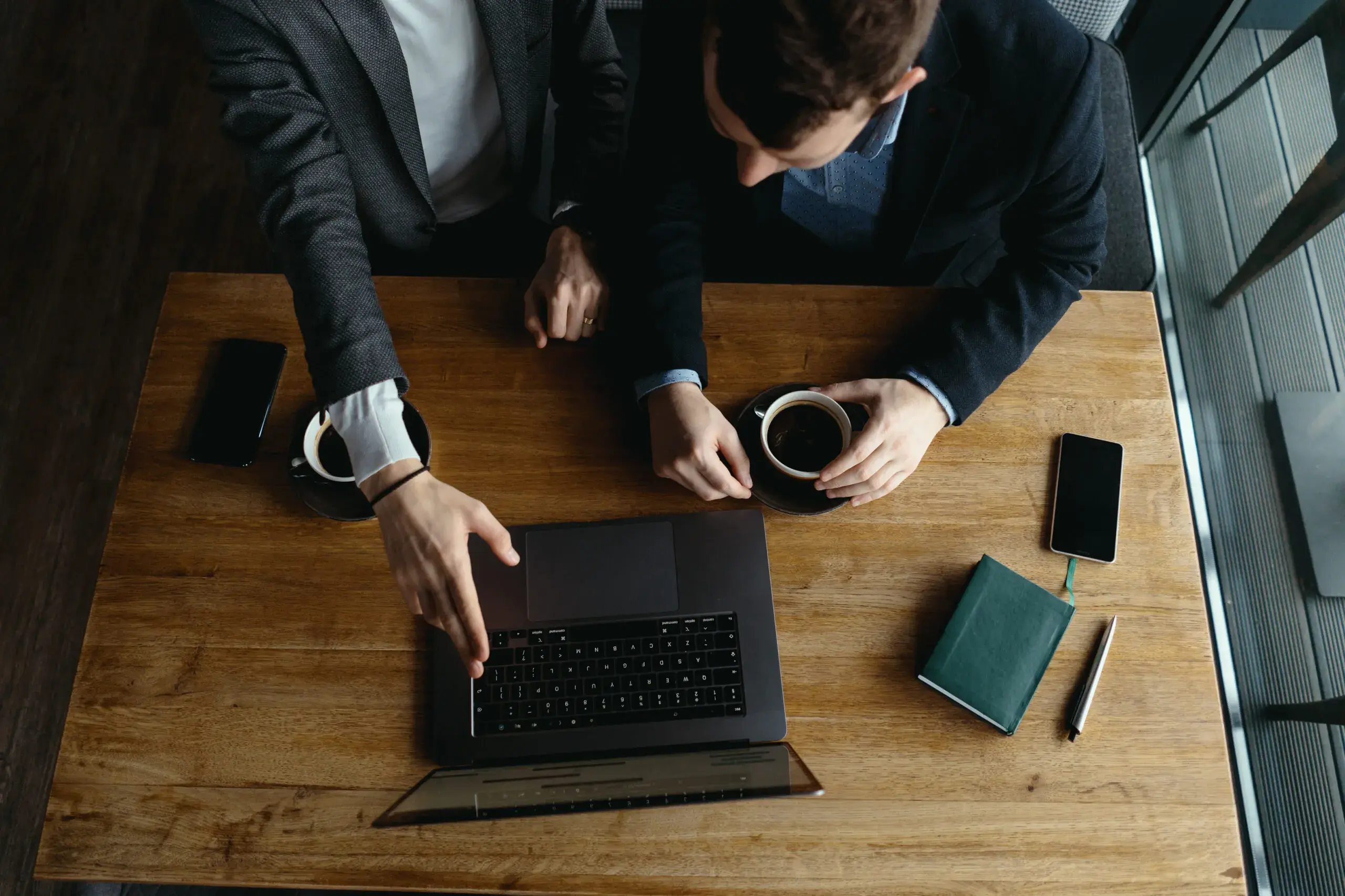 two-businessmen-pointing-laptop-screen-while-discussing-scaled