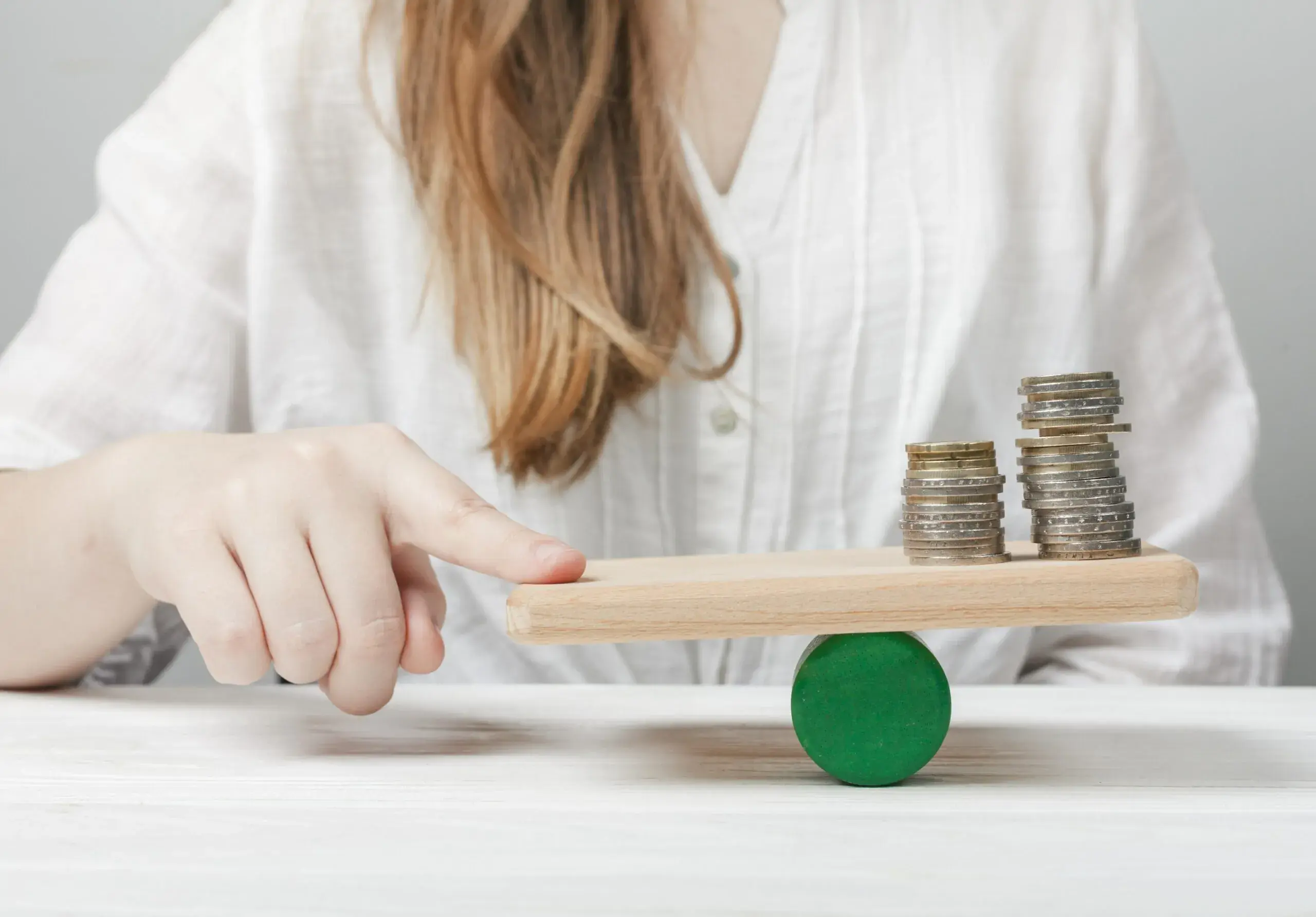 woman-holding-her-finger-balance-with-coins-scaled